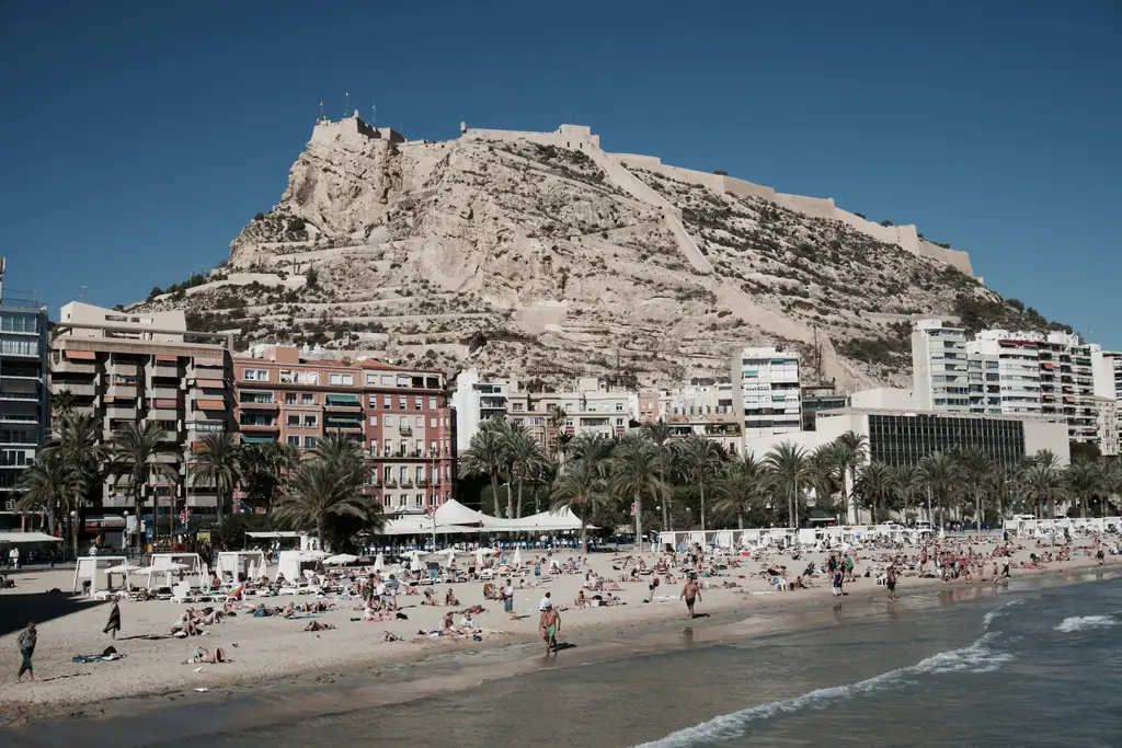 Strand und Häuser in Alicante unter blauem Himmel