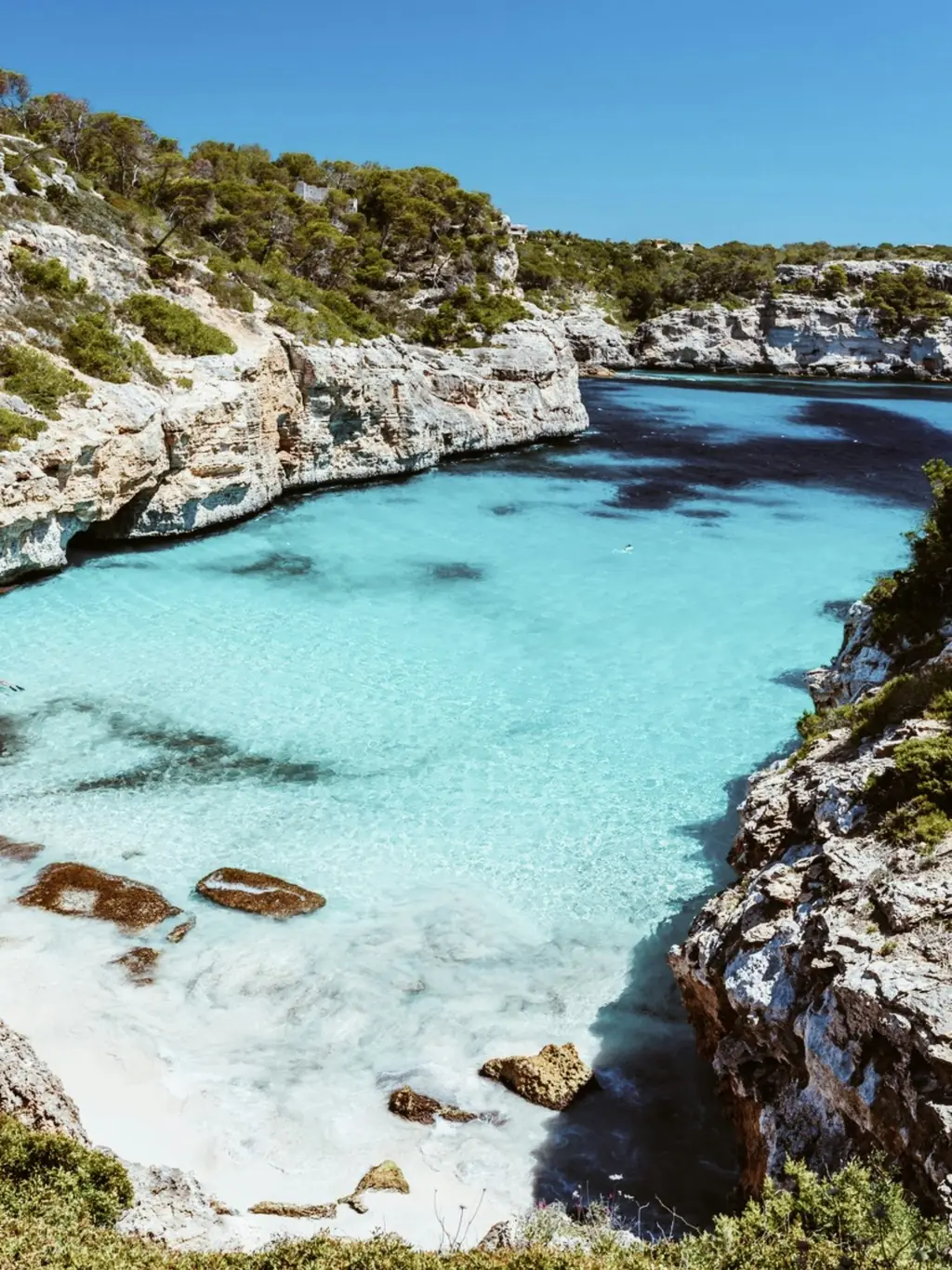 Schmale Bucht mit türkisfarbenem Wasser zwischen hellen Felsen