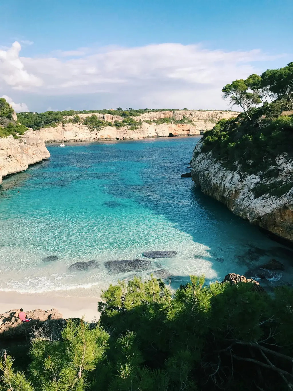 Bucht mit kleinem Sandstrand und Pinien an den Felsen