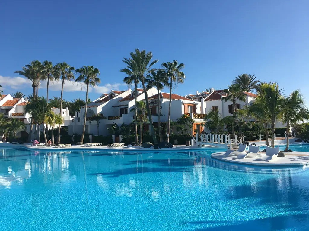 Hotelpool mit Palmen und weißen Gebäuden