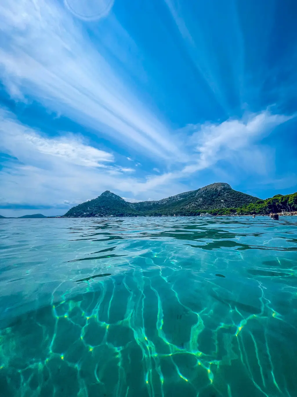 Klares Meerwasser vor einer bergigen Küste