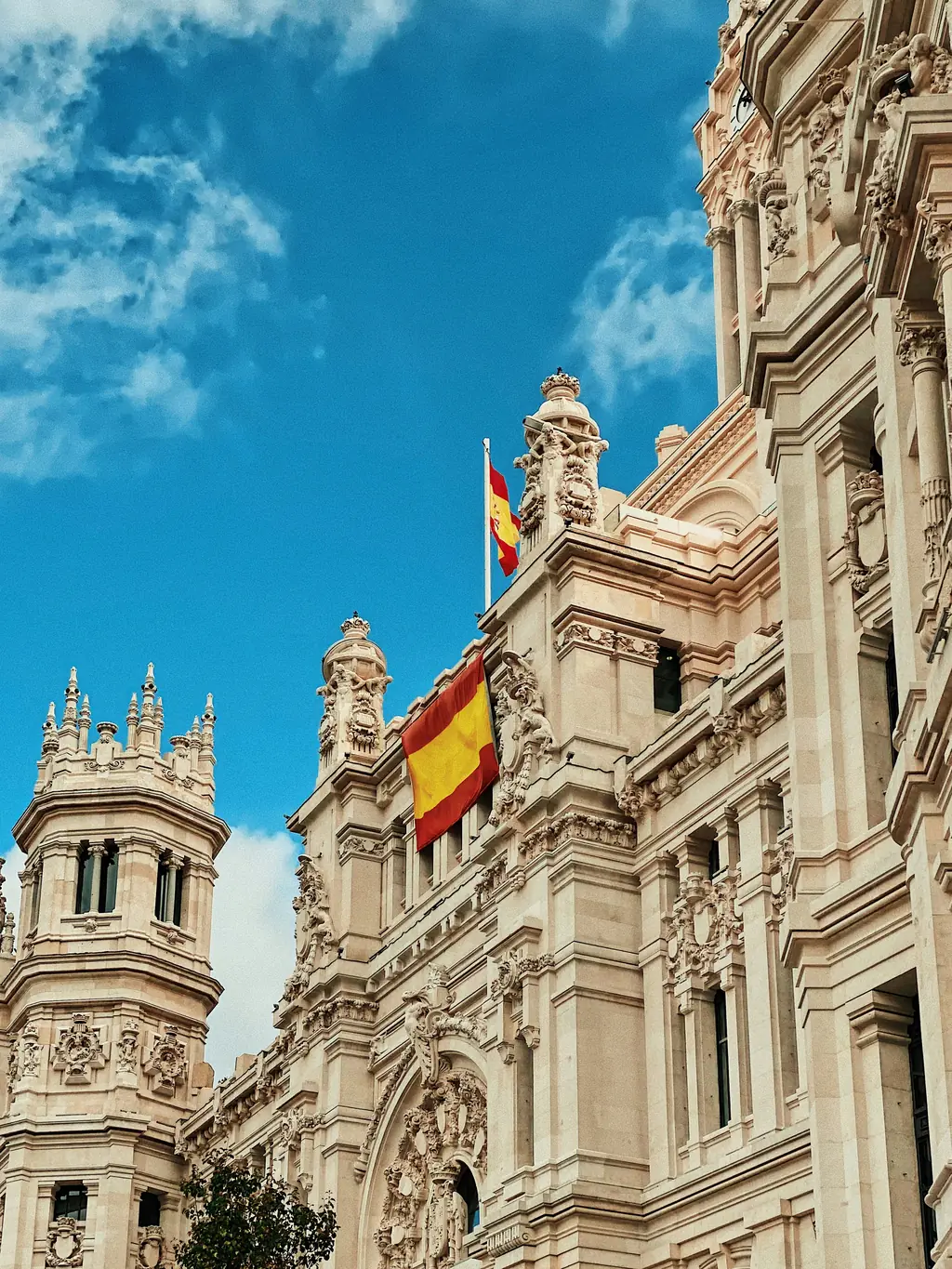 Fassade des Palacio de Cibeles in Madrid mit spanischer Flagge