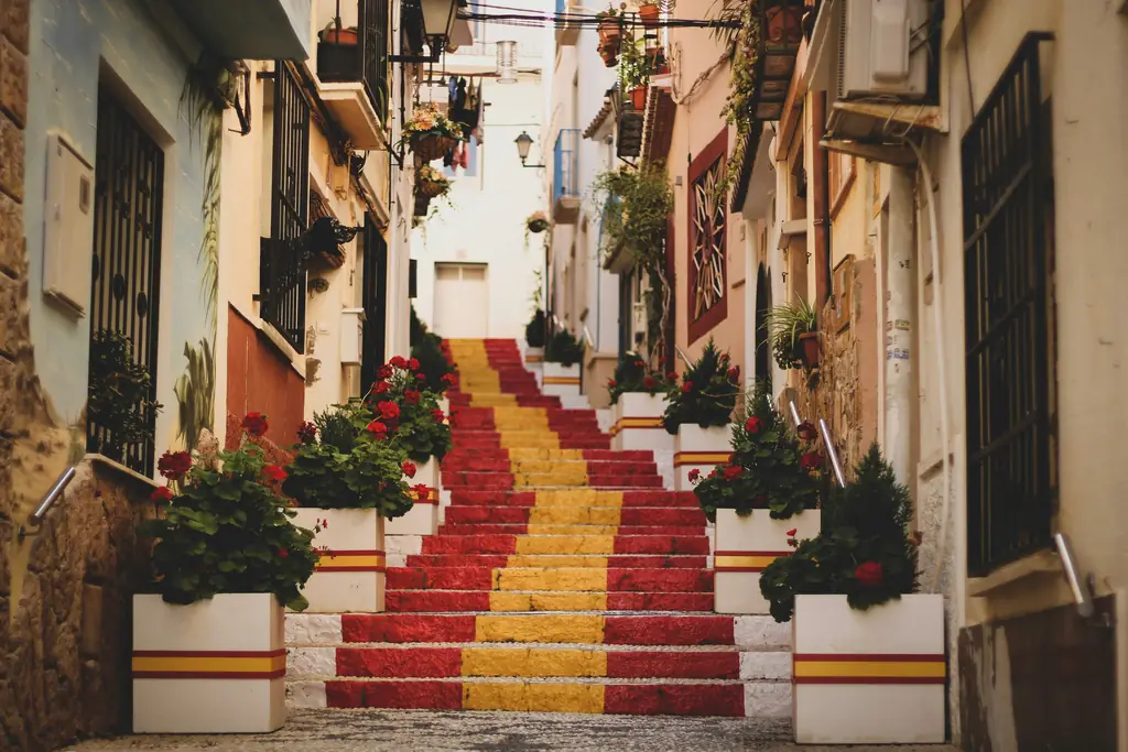 Treppe in den Farben der spanischen Flagge mit Blumenkübeln